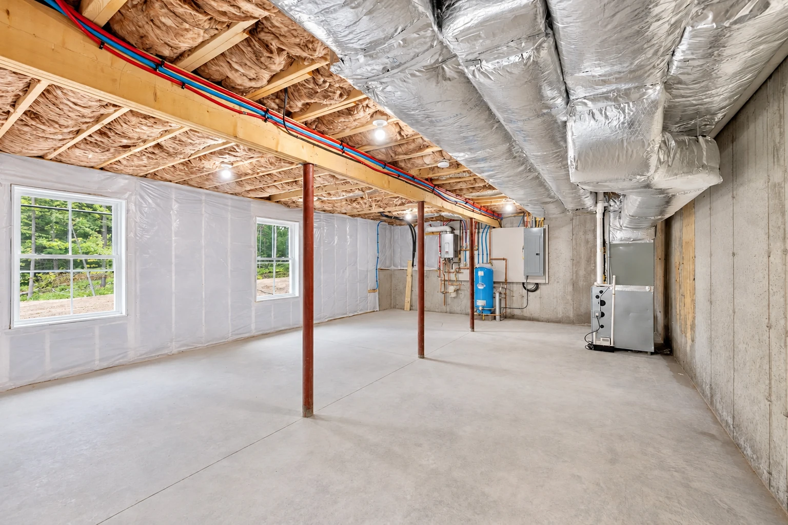 Insulated basement with exposed ceiling joists, silver-wrapped ducts, plastic-covered walls, windows and utility equipment.